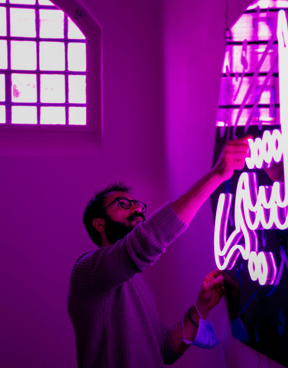 Liam Monzer Alzafari (30) står bak kunstprosjektet «Words». Her klargjør han et av de arabiske neonskiltene til utstillingen åpnes på Interkulturelt museum.