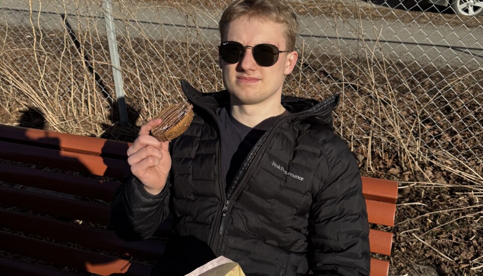 NYTER: Fredrik nyter kjeksen i godværet på en benk rett ved.