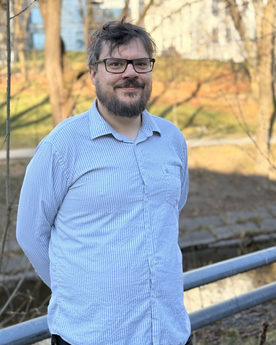 SPRÅK FØLES, IKKE FORKLARES: Gjennom L’ecart utforsker Jonsson hvordan poesi kan kommunisere uten felles språk. Jonathan, person i blå skjorte med briller foran solfylte Akerselva