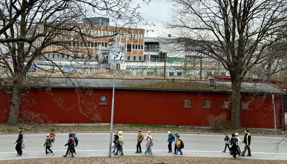 Bildet viser Normannsløkka bak den røde gjenvinningsstasjonen, og barn på tur.